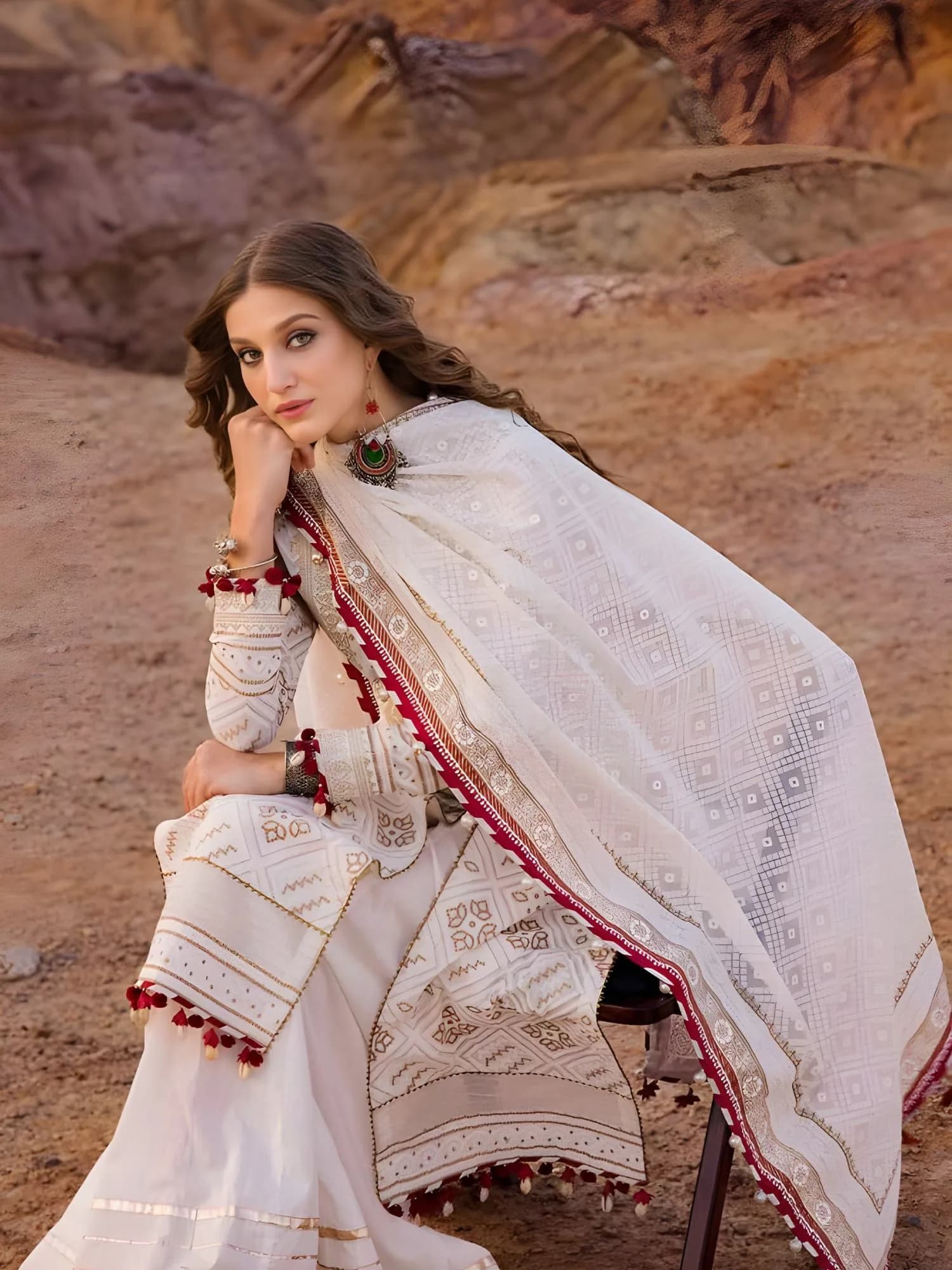 Side angle of embroidered lawn suit with statement earrings and flowing dupatta drape