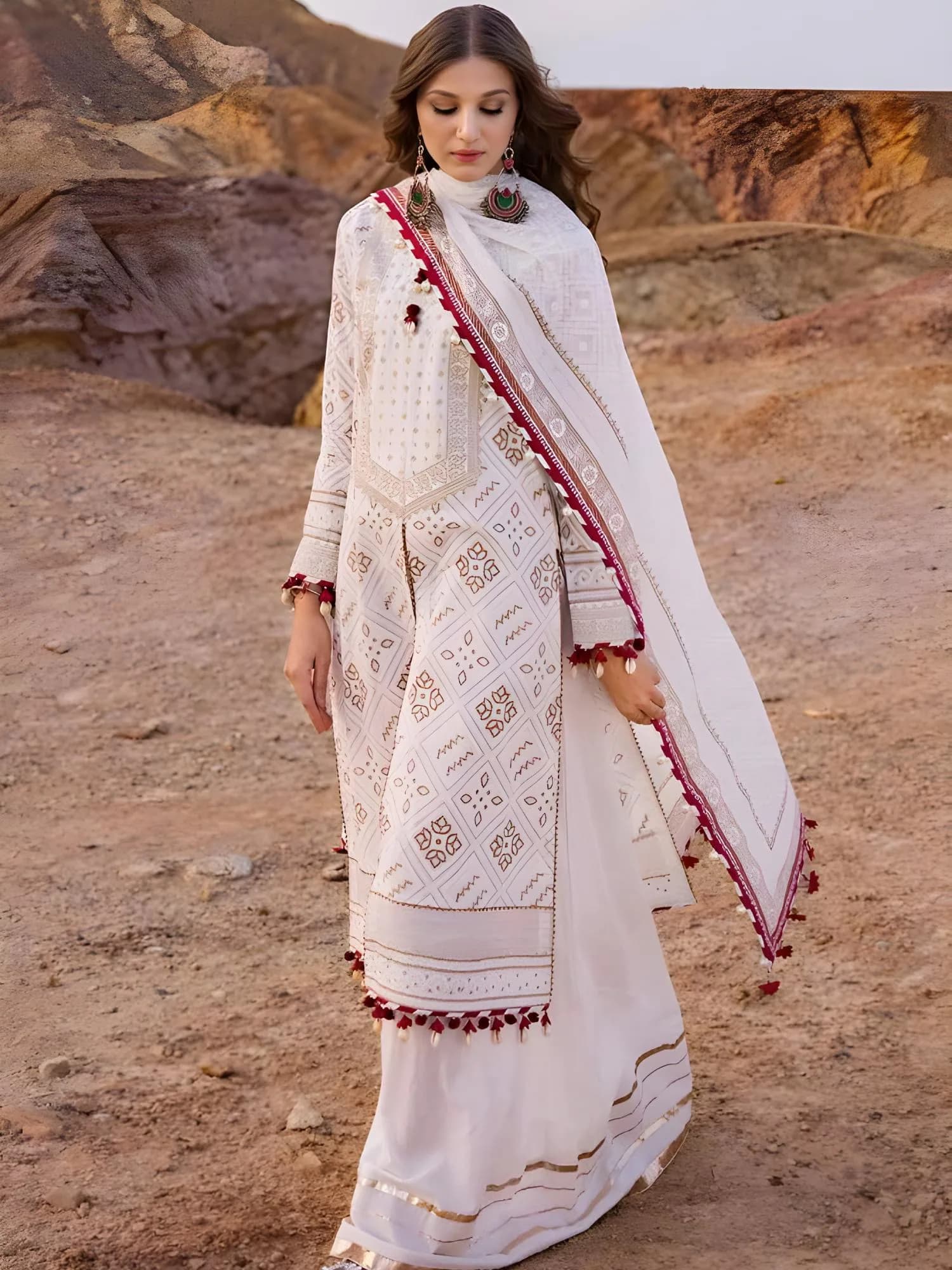 Front view of off-white lawn suit with gold lacquer print and maroon pom-pom trim dupatta